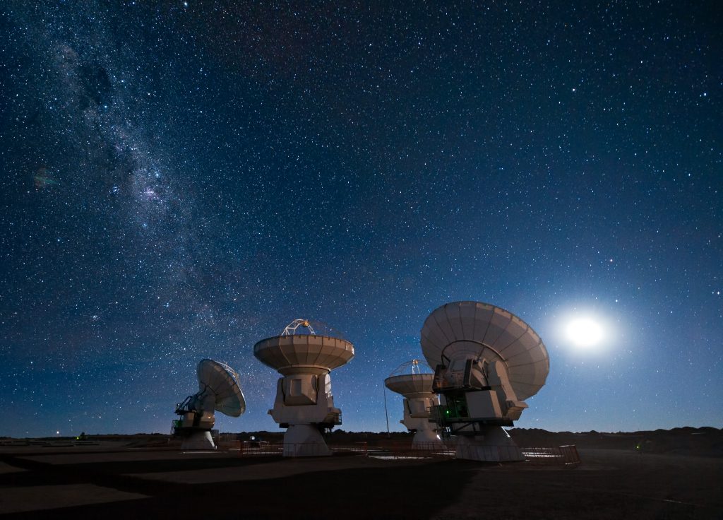 Four antennas of the Atacama Large Millimeter/submillimeter Array (ALMA) gaze up at the star-filled night sky, in anticipation of the work that lies ahead. The Moon lights the scene on the right, while the band of the Milky Way stretches across the upper left. ALMA is being constructed at an altitude of 5000 m on the Chajnantor plateau in the Atacama Desert in Chile. This is one of the driest places on Earth and this dryness, combined with the thin atmosphere at high altitude, offers superb conditions for observing the Universe at millimetre and submillimetre wavelengths. At these long wavelengths, astronomers can probe, for example, molecular clouds, which are dense regions of gas and dust where new stars are born when a cloud collapses under its own gravity. Currently, the Universe remains relatively unexplored at submillimetre wavelengths, so astronomers expect to uncover many new secrets about star formation, as well as the origins of galaxies and planets, when ALMA is operational. The ALMA project is a partnership of Europe, North America and East Asia in cooperation with the Republic of Chile. This panorama was taken by ESO Photo Ambassador José Francisco Salgado. Links ESO Photo Ambassadors webpage.