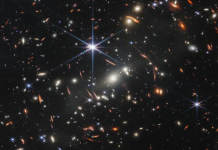 O lentilă gravitațională dezvăluie o galaxie formată la doar 800 de milioane de ani după Big Bang